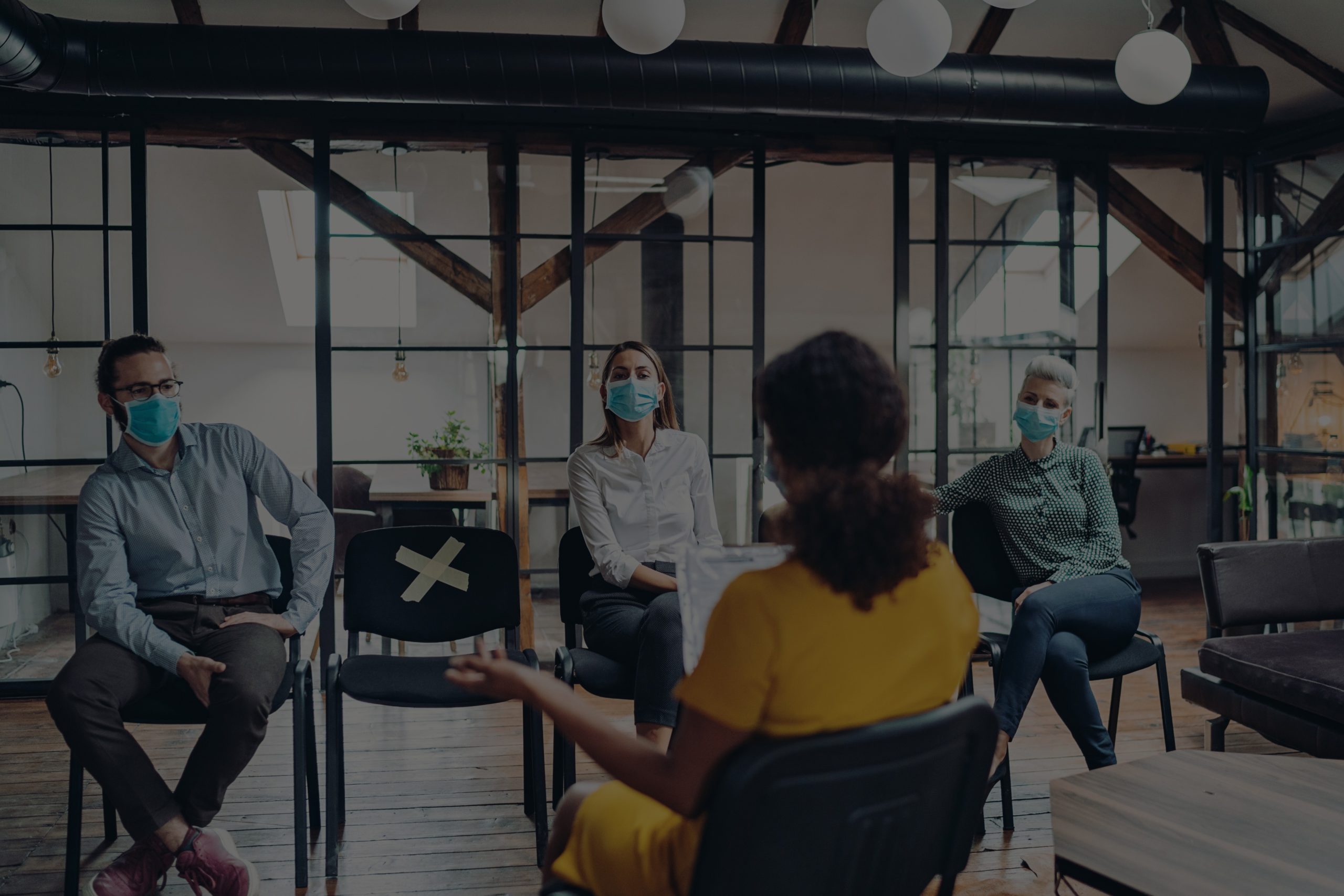 Featured Image. Business persons with protective masks during a meeting in the office