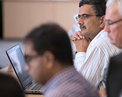 Image of multiple people participating in a boardroom meeting.