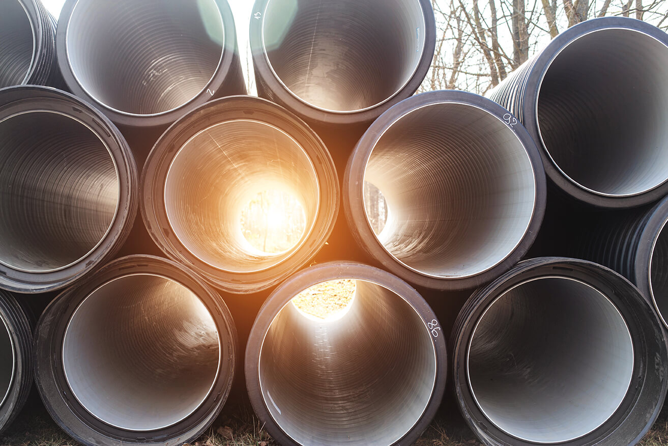 Drainage system pipes piled on top of each other and prepared for construction.