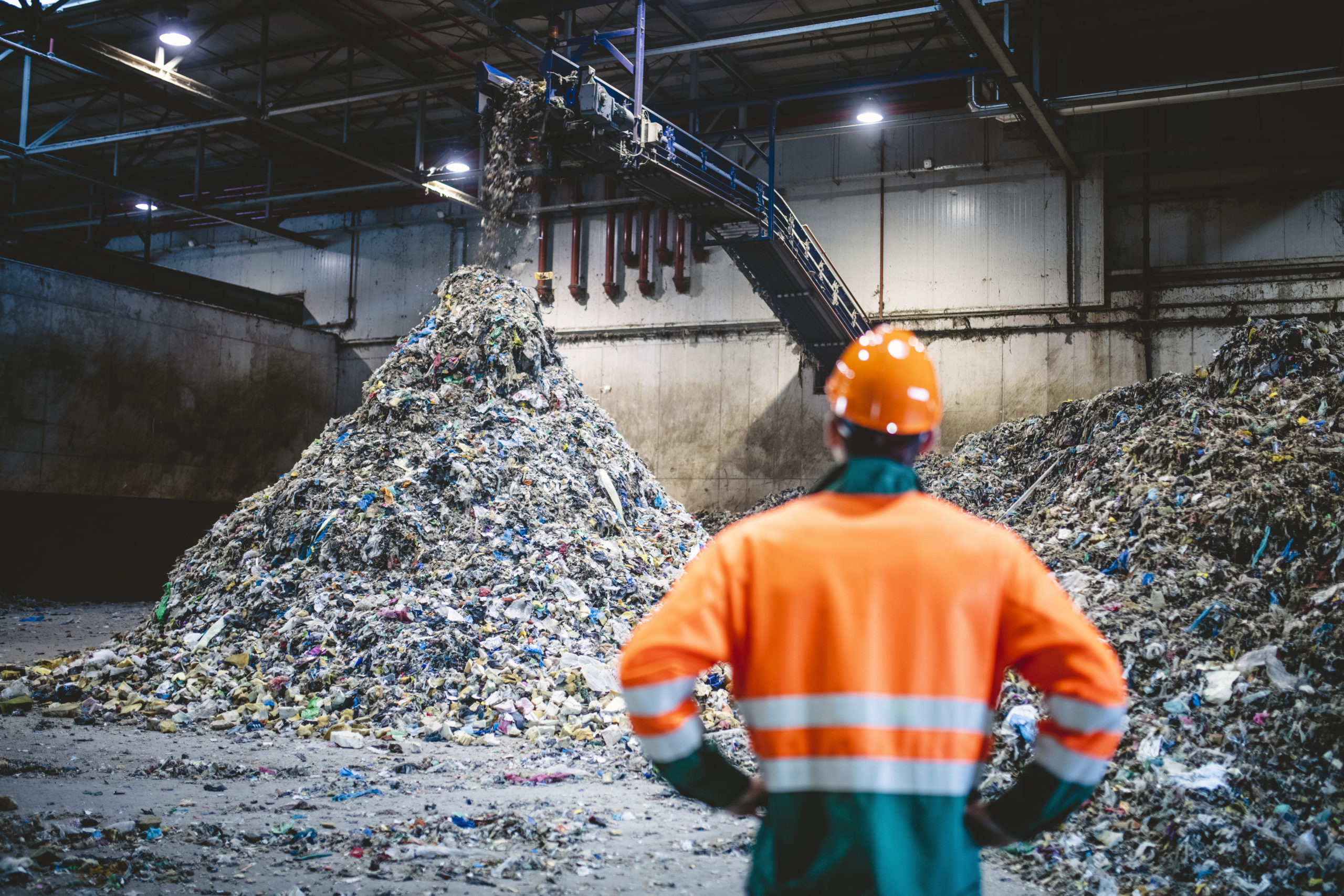 L'image sélectionnée. Worker Observing Processing of Waste at Recycling Facility