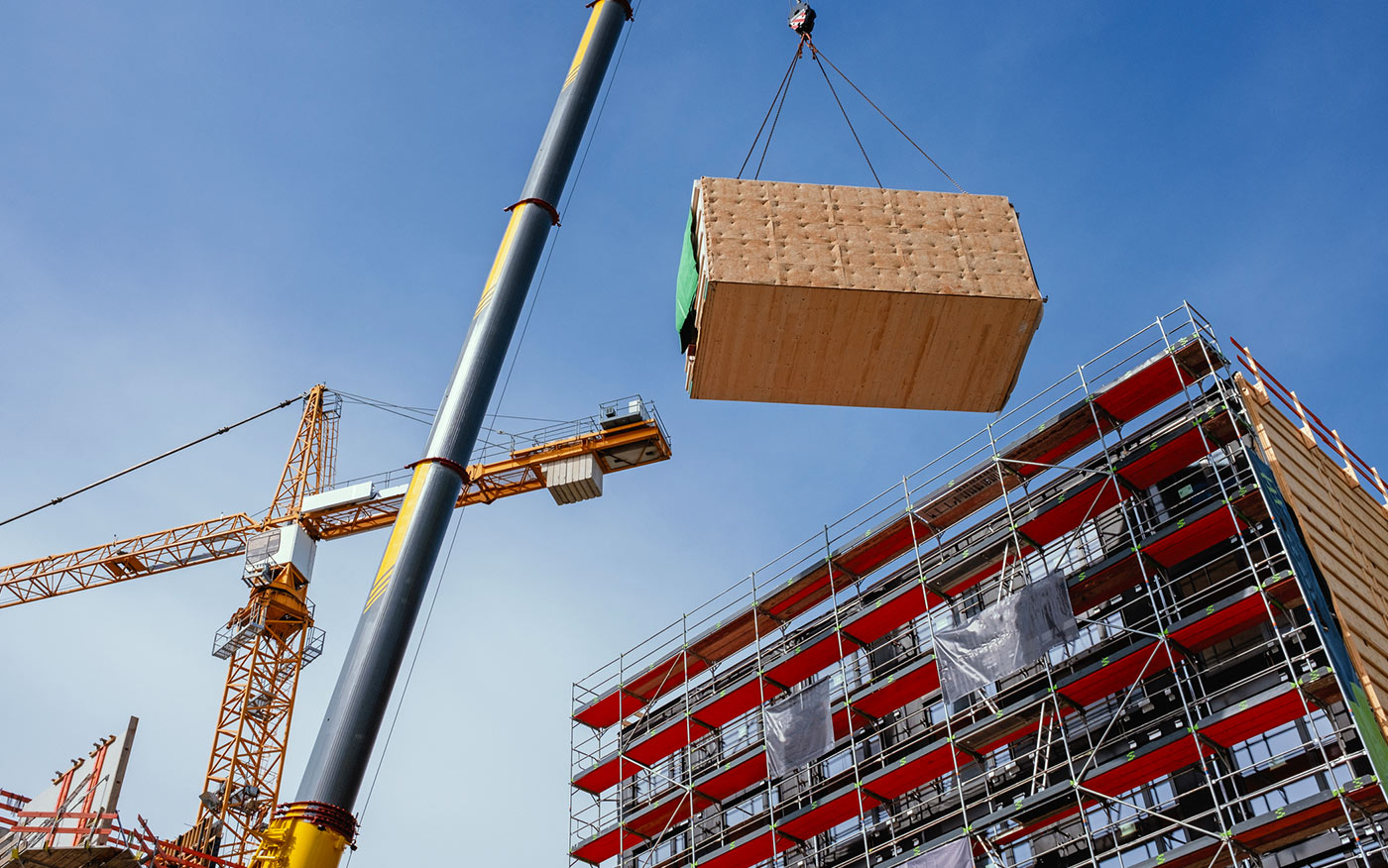 L'image sélectionnée. A crane lifting a building module to the top of a highrise structure.