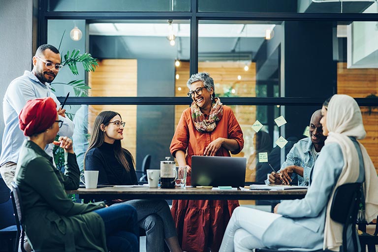 L'image sélectionnée. A diverse group of employees around the table in the office